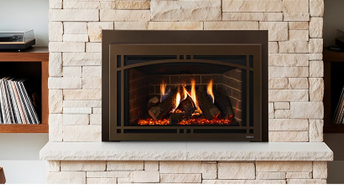 Majestic gas fireplace insert with a glowing flame installed in a fireplace opening