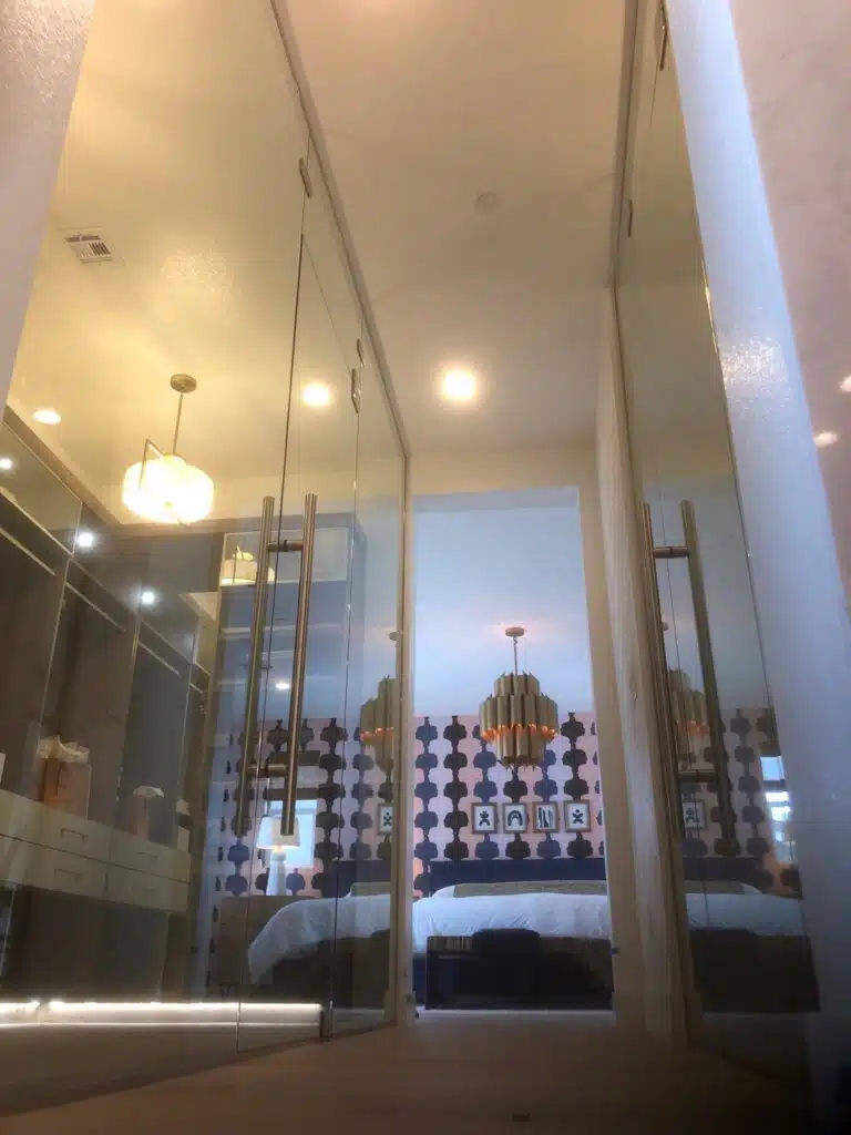 A hallway with glass doors leading to a bedroom and closet.
