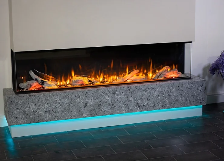 A modern electric fireplace with a sleek design featuring realistic-looking flames and logs. The Valor Electric Fireplace Inserts are encased in a stone-like mantel with a subtle blue LED light underneath, set against a plain wall on a dark tiled floor.