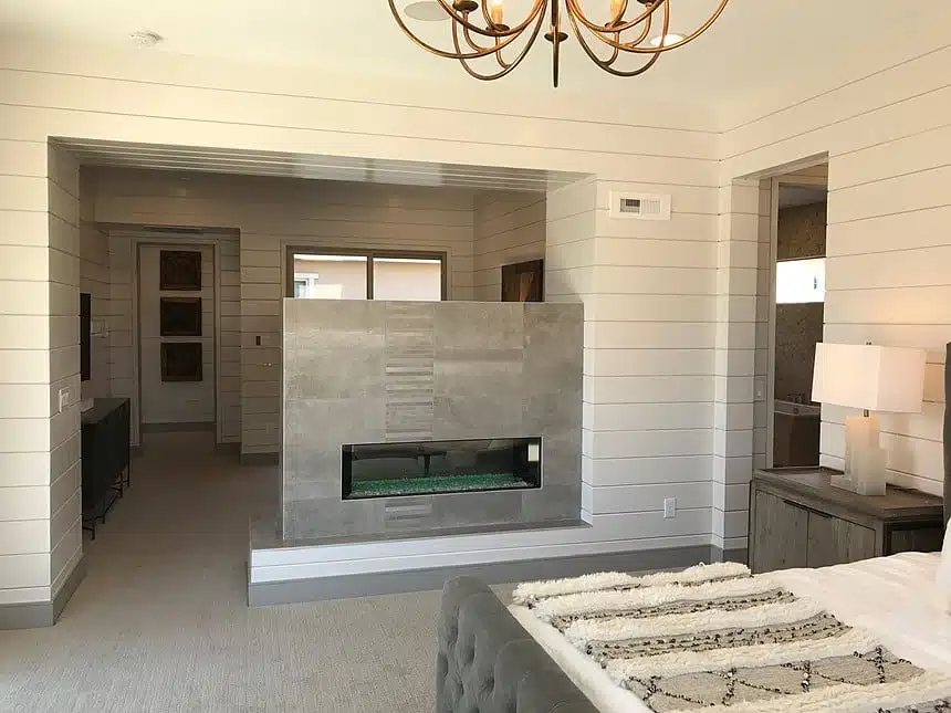 Modern bedroom with a sleek two-sided fireplace