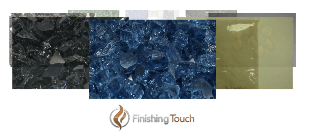 An array of colored glass pieces, including black, blue, and yellow, arranged in overlapping rectangles. Below the fire glass pieces is the logo of "Finishing Touch," featuring a stylized flame icon and the company name in mixed brown and gray text.