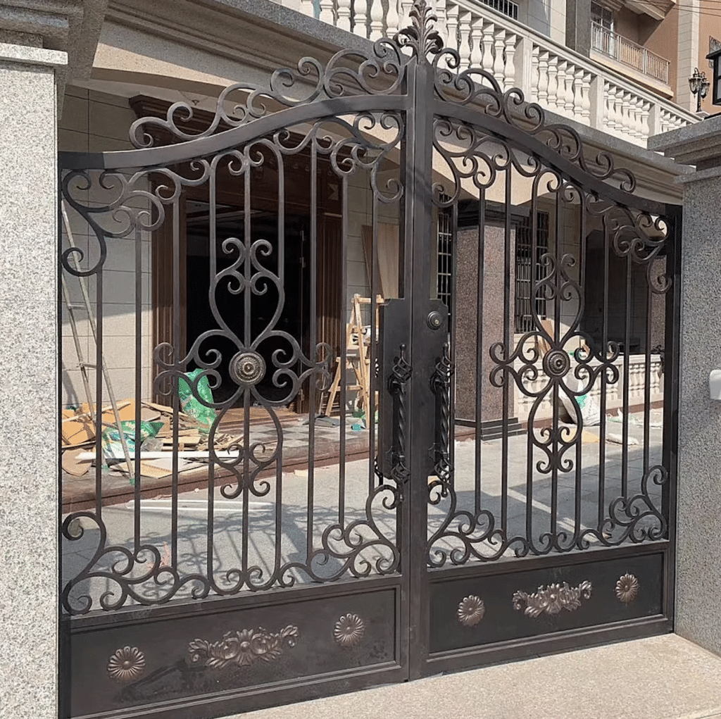 A decorative wrought iron gate with ornate designs stands partially open, offering a glimpse into a courtyard or entrance area. The gate features intricate scrollwork and floral patterns, with a symmetrical design and a blend of traditional and elegant styles reminiscent of classic Iron Gates in Las Vegas.