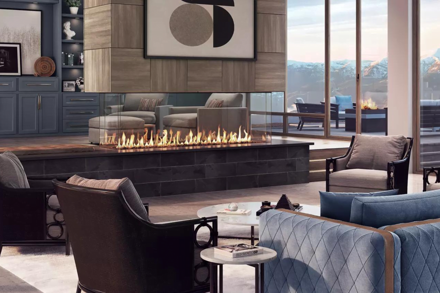 A modern living room featuring a sleek, glass-enclosed fireplace. The space is furnished with elegant chairs, a blue couch, and a round side table. A large window offers an outdoor view of mountains in the distance, and contemporary artwork adorns the wall above the fireplace.