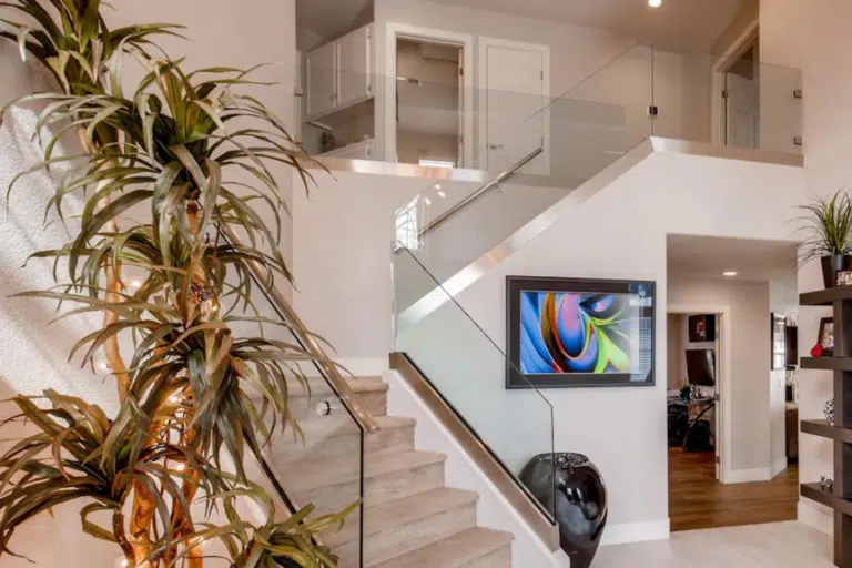 A modern Las Vegas home interior showcases a staircase with custom glass railings installed by Hearth & Home Specialties