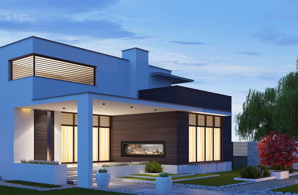 A modern two-story house with large windows and horizontal wooden accents is surrounded by a neatly landscaped yard. The evening sky adds a serene backdrop. A fireplace is visible through the glass, and a small garden decorates the front.